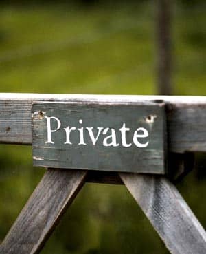 A sign on a fence saying private.